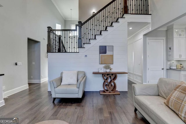 living room with crown molding, high vaulted ceiling, and hardwood / wood-style flooring