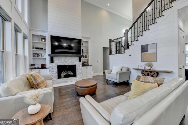 living room featuring a fireplace, a high ceiling, and dark wood-type flooring