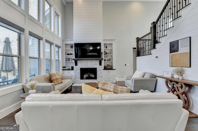 living room with a fireplace, a healthy amount of sunlight, and dark wood-type flooring