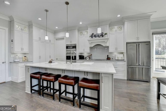 kitchen featuring white cabinets, an island with sink, and appliances with stainless steel finishes