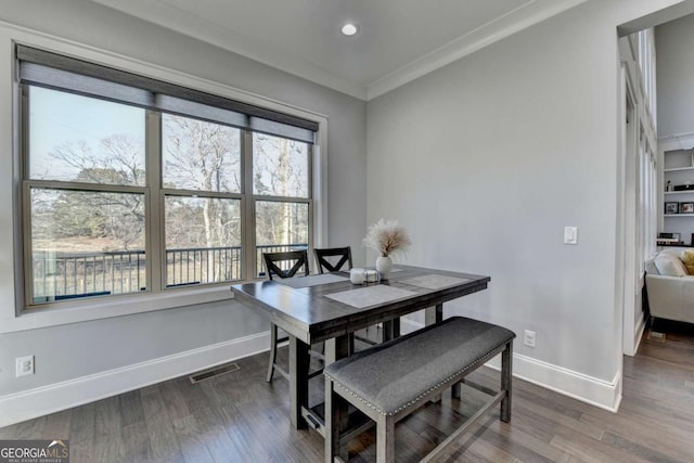 dining room featuring dark hardwood / wood-style flooring and crown molding