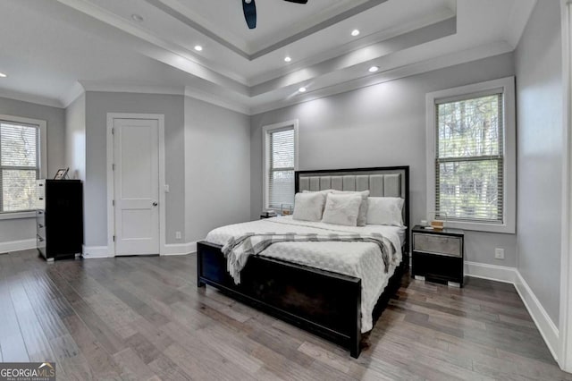 bedroom with ceiling fan, wood-type flooring, crown molding, and a tray ceiling