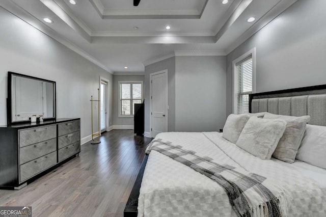 bedroom featuring hardwood / wood-style floors, a raised ceiling, and crown molding