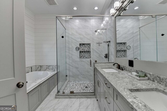 bathroom featuring vanity and independent shower and bath