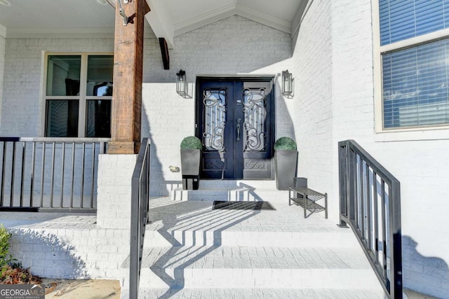 view of exterior entry featuring french doors and a porch