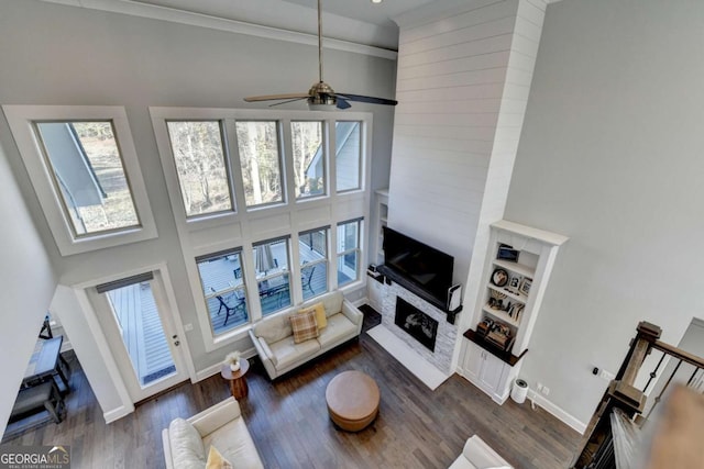 living room with a wealth of natural light, a towering ceiling, and ceiling fan