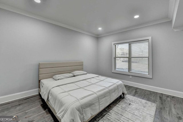 bedroom with wood-type flooring and ornamental molding