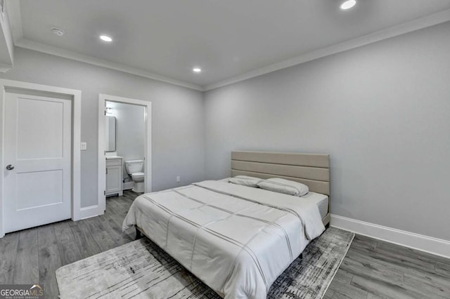 bedroom with ensuite bath, hardwood / wood-style flooring, and ornamental molding