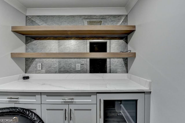 bar featuring light stone counters and wine cooler