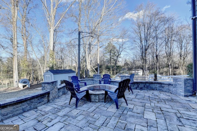 view of patio / terrace with a shed and an outdoor fire pit