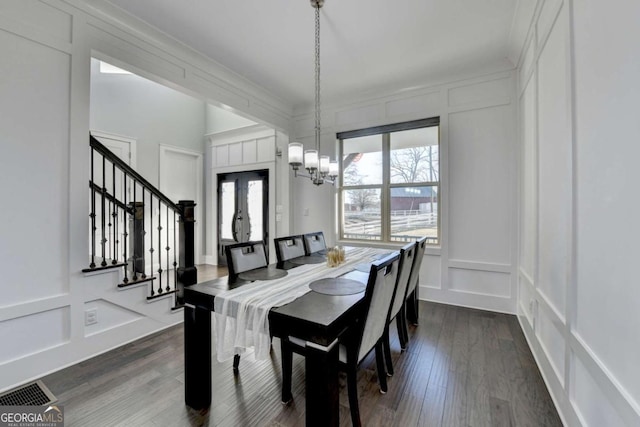 dining area with dark hardwood / wood-style flooring and an inviting chandelier