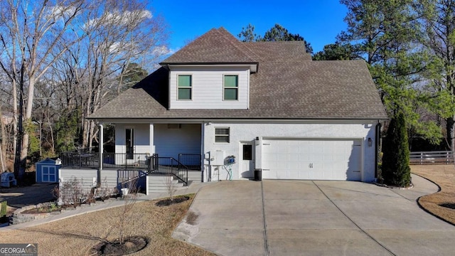 view of front of home featuring covered porch, a garage, and a storage shed