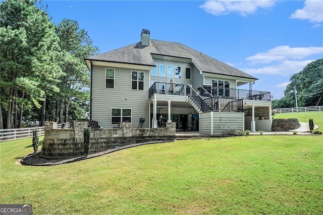 rear view of house featuring a lawn and a wooden deck