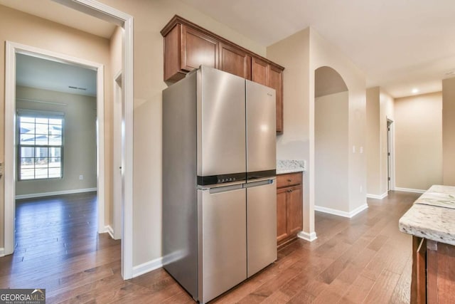 kitchen featuring stainless steel fridge and hardwood / wood-style flooring