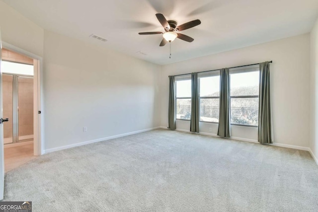 spare room with ceiling fan and light colored carpet