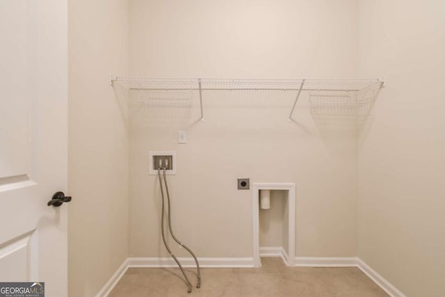 clothes washing area featuring hookup for an electric dryer, light tile patterned floors, and hookup for a washing machine