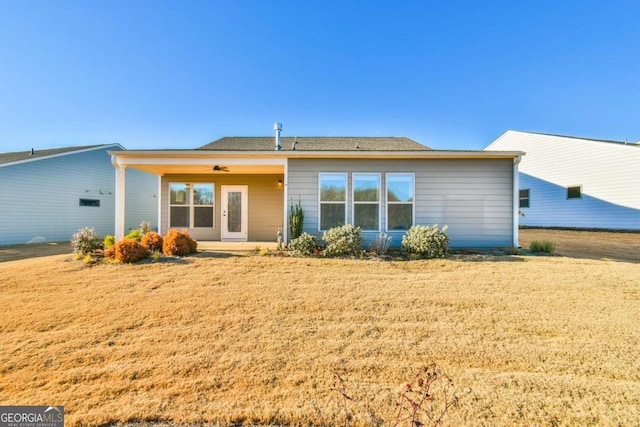 back of house featuring ceiling fan and a lawn