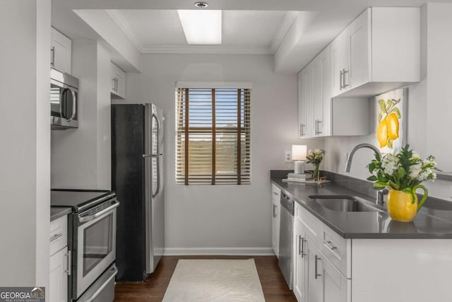 kitchen featuring stainless steel appliances, ornamental molding, sink, and white cabinets