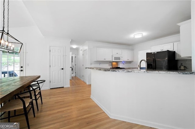 kitchen featuring pendant lighting, white cabinetry, black refrigerator with ice dispenser, and light hardwood / wood-style floors