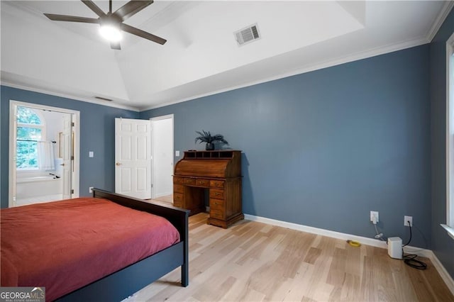 bedroom with ceiling fan, light hardwood / wood-style floors, ornamental molding, and a tray ceiling