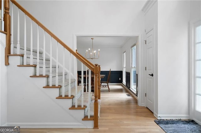 entrance foyer with light wood-type flooring and a notable chandelier