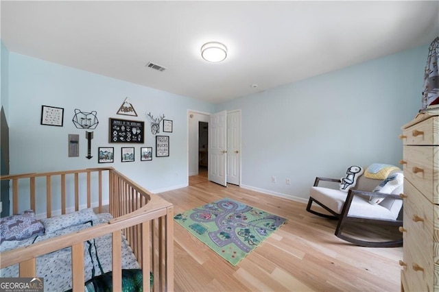 bedroom featuring a crib and hardwood / wood-style floors