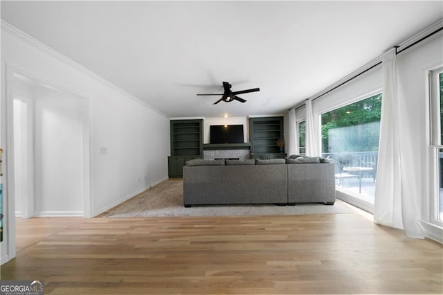 unfurnished living room with ceiling fan, light hardwood / wood-style floors, and ornamental molding