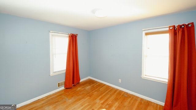 empty room featuring a wealth of natural light and light hardwood / wood-style floors