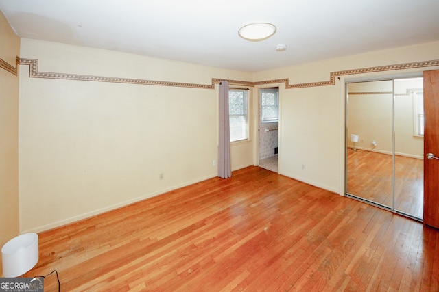 unfurnished bedroom with a closet and wood-type flooring