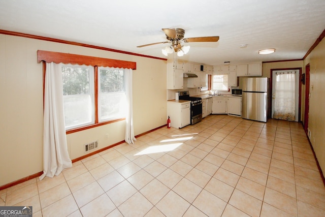 kitchen featuring plenty of natural light, sink, stainless steel appliances, and white cabinetry