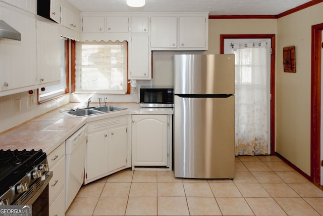 kitchen featuring appliances with stainless steel finishes, tile counters, white cabinetry, sink, and light tile patterned flooring