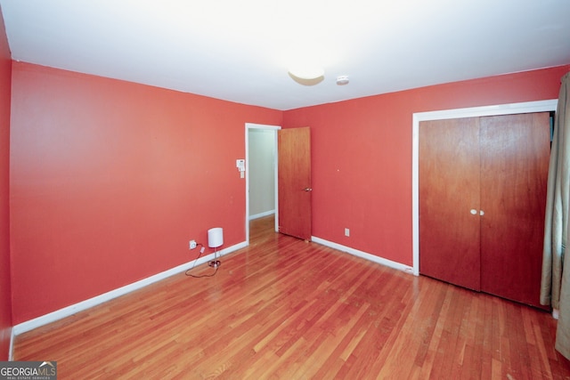 unfurnished bedroom with wood-type flooring and a closet