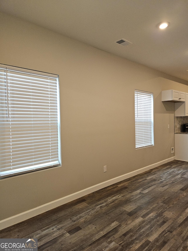 unfurnished room with dark wood-type flooring