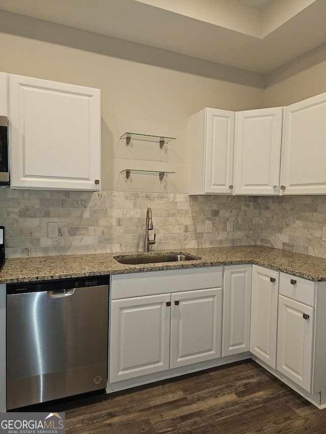 kitchen featuring white cabinetry, stainless steel appliances, dark stone countertops, sink, and backsplash