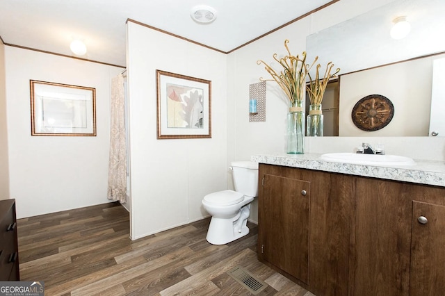 bathroom featuring crown molding, wood-type flooring, toilet, and vanity