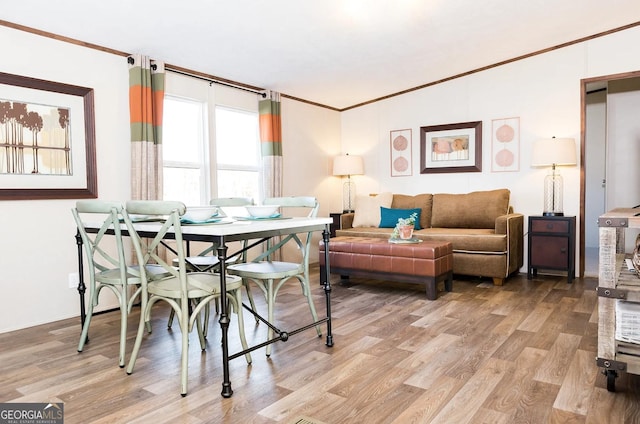 dining area featuring light hardwood / wood-style flooring and ornamental molding