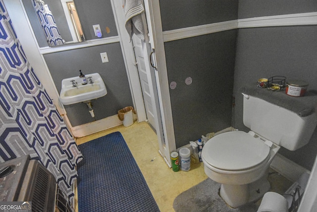 bathroom featuring a shower with curtain, toilet, and sink