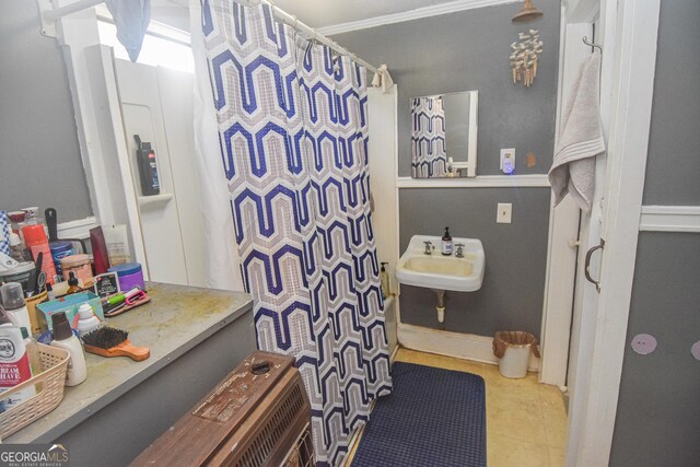 bathroom featuring tile patterned floors, crown molding, and sink