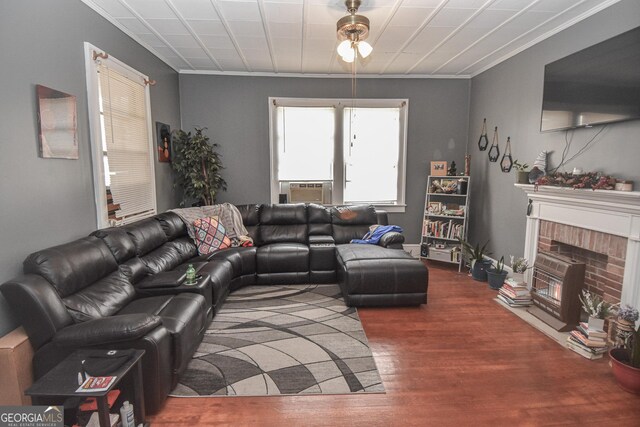 living room with a fireplace, crown molding, cooling unit, and dark wood-type flooring