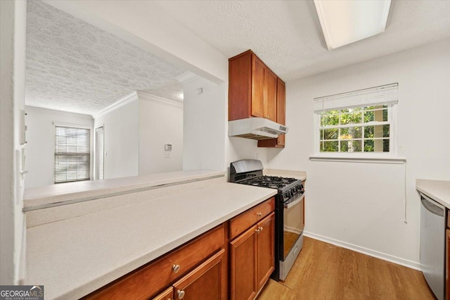 kitchen featuring crown molding, light hardwood / wood-style flooring, stainless steel appliances, and a textured ceiling