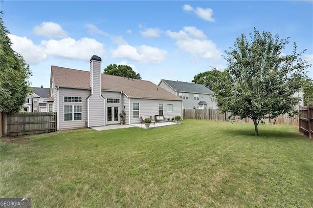 back of property with french doors, a yard, and a patio area