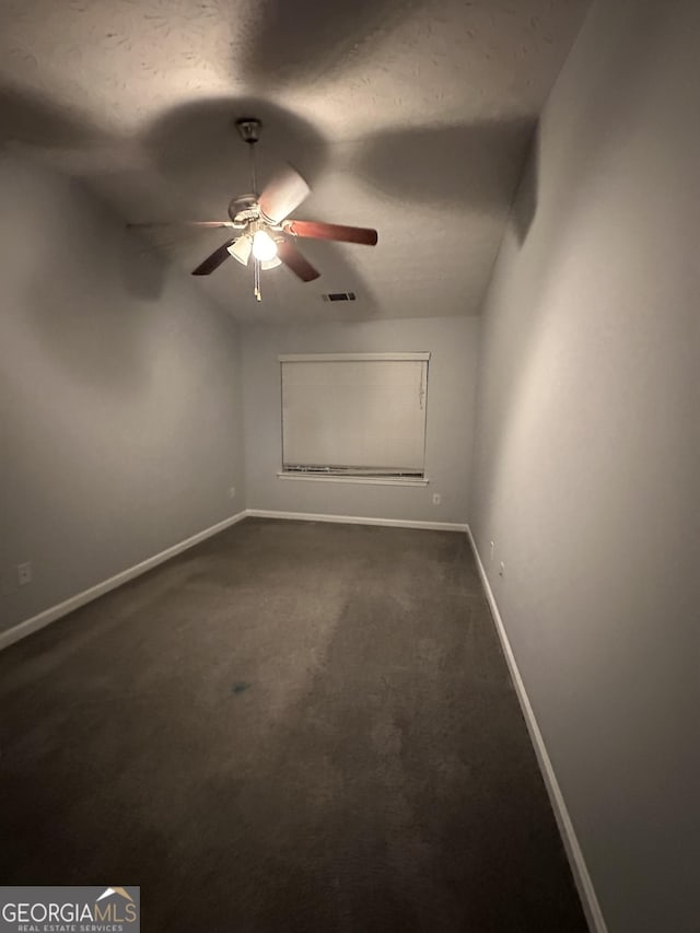 spare room featuring dark carpet