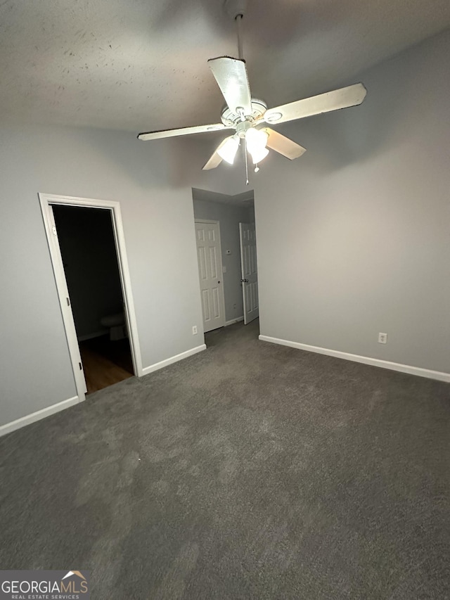 unfurnished bedroom with connected bathroom, ceiling fan, a textured ceiling, and dark colored carpet