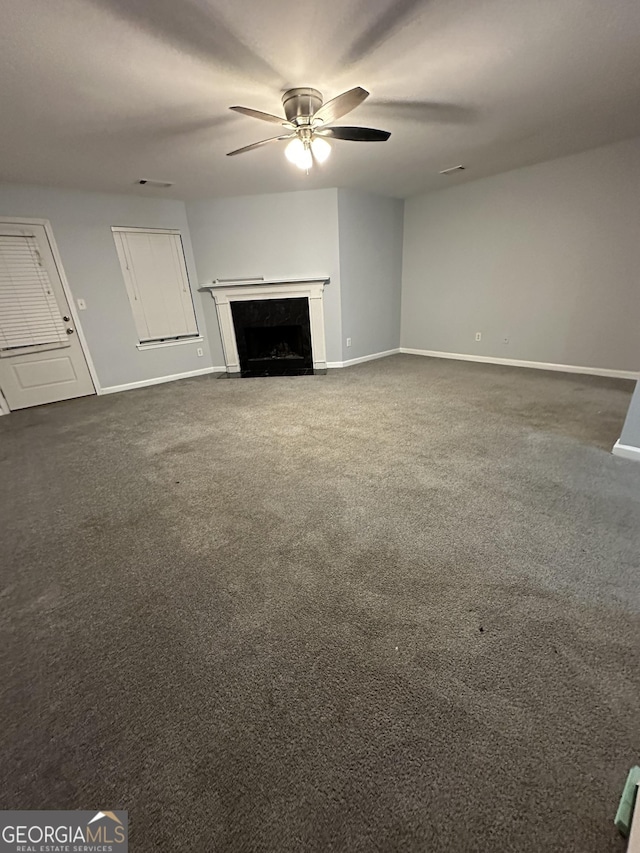 unfurnished living room with ceiling fan and dark carpet