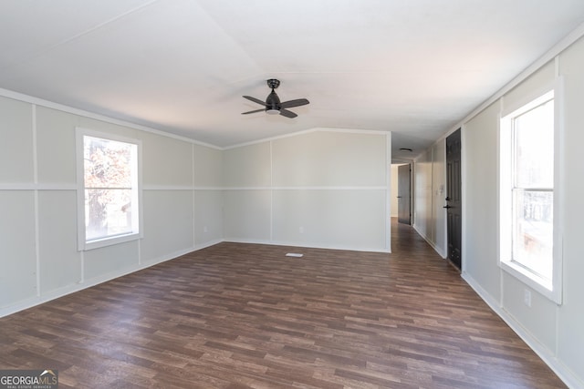 spare room with ceiling fan, a healthy amount of sunlight, dark hardwood / wood-style flooring, and vaulted ceiling