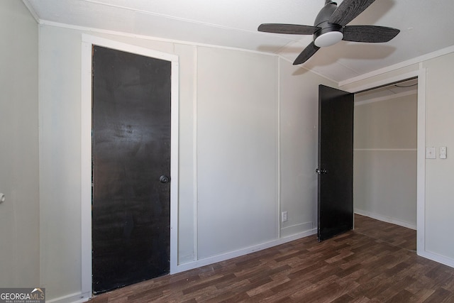 unfurnished bedroom featuring ceiling fan, dark hardwood / wood-style flooring, ornamental molding, and a closet