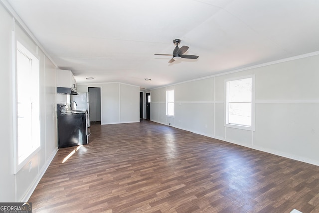 unfurnished living room with ceiling fan, a healthy amount of sunlight, and dark hardwood / wood-style floors