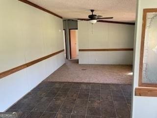 spare room with ceiling fan, crown molding, and a textured ceiling