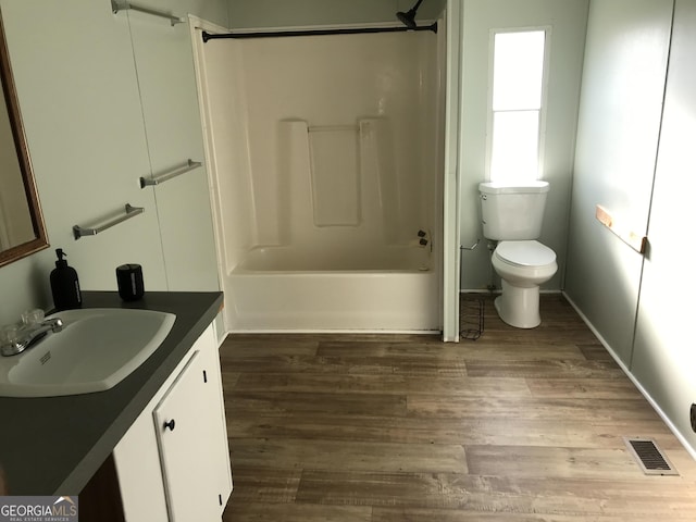 full bathroom featuring shower / bathing tub combination, vanity, wood-type flooring, and toilet