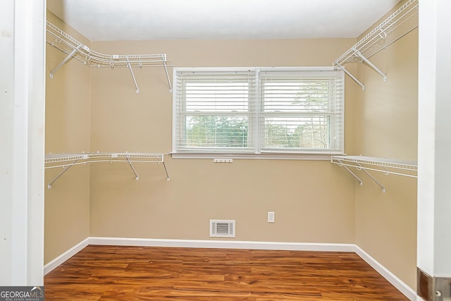 walk in closet with hardwood / wood-style floors